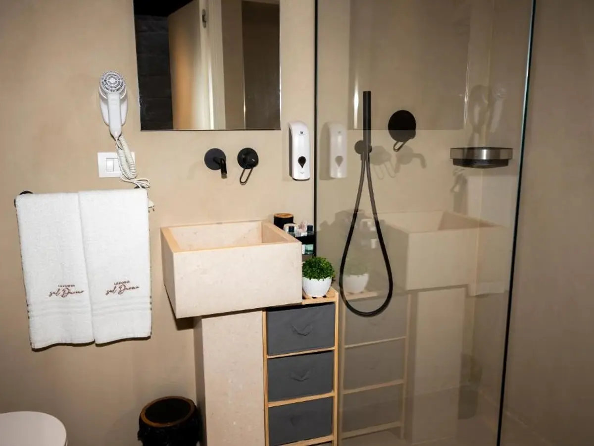 Bagno con doccia e mobile in legno